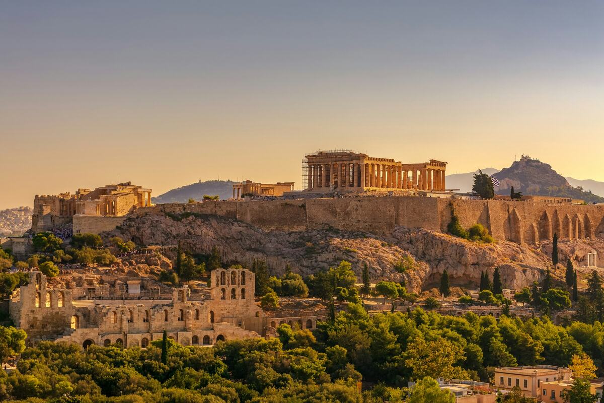 De Akropolis in Athene in warm avondlicht, boven groene hellingen
